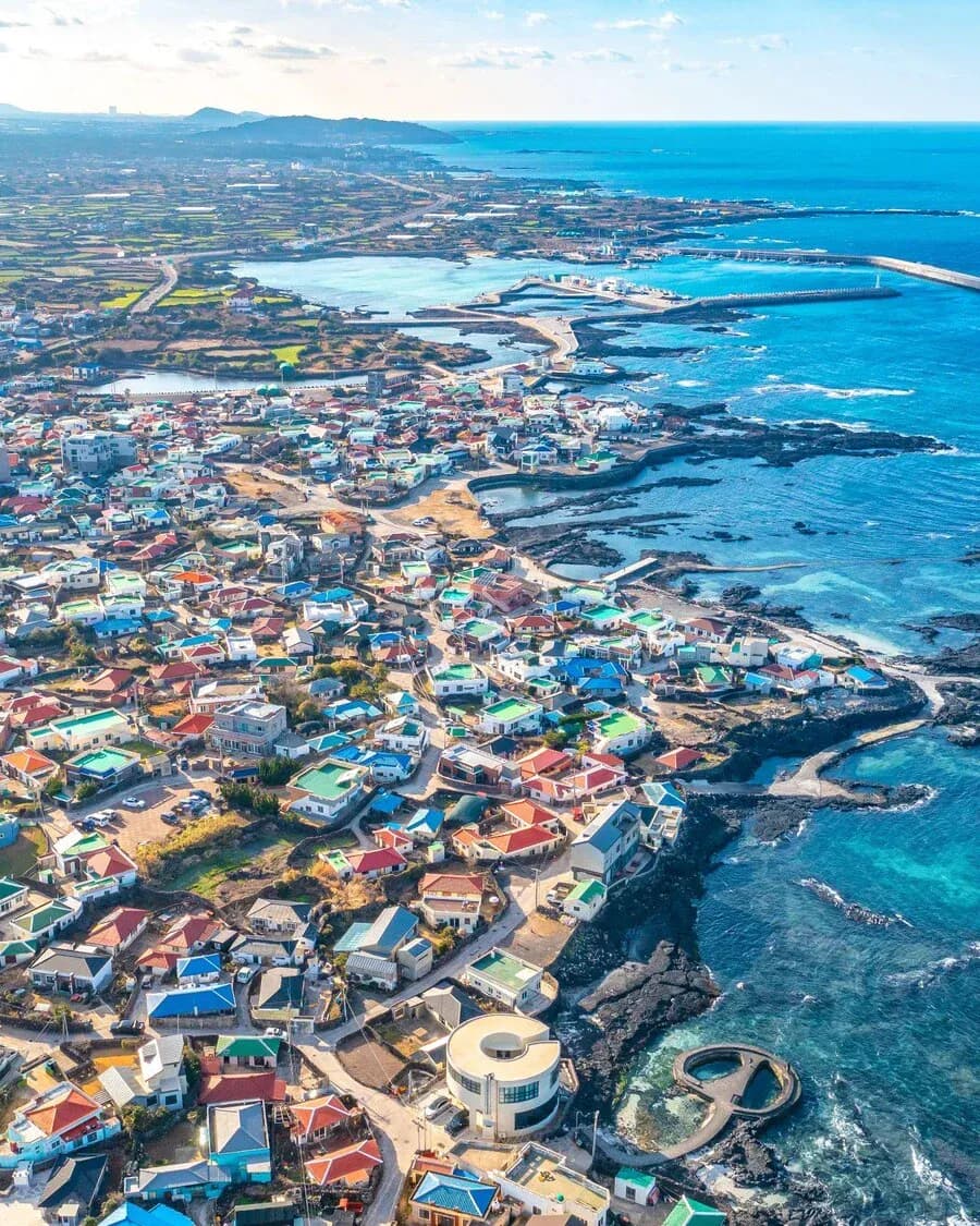 Aerial view of a colourful Jeju seaside village and tidal pools