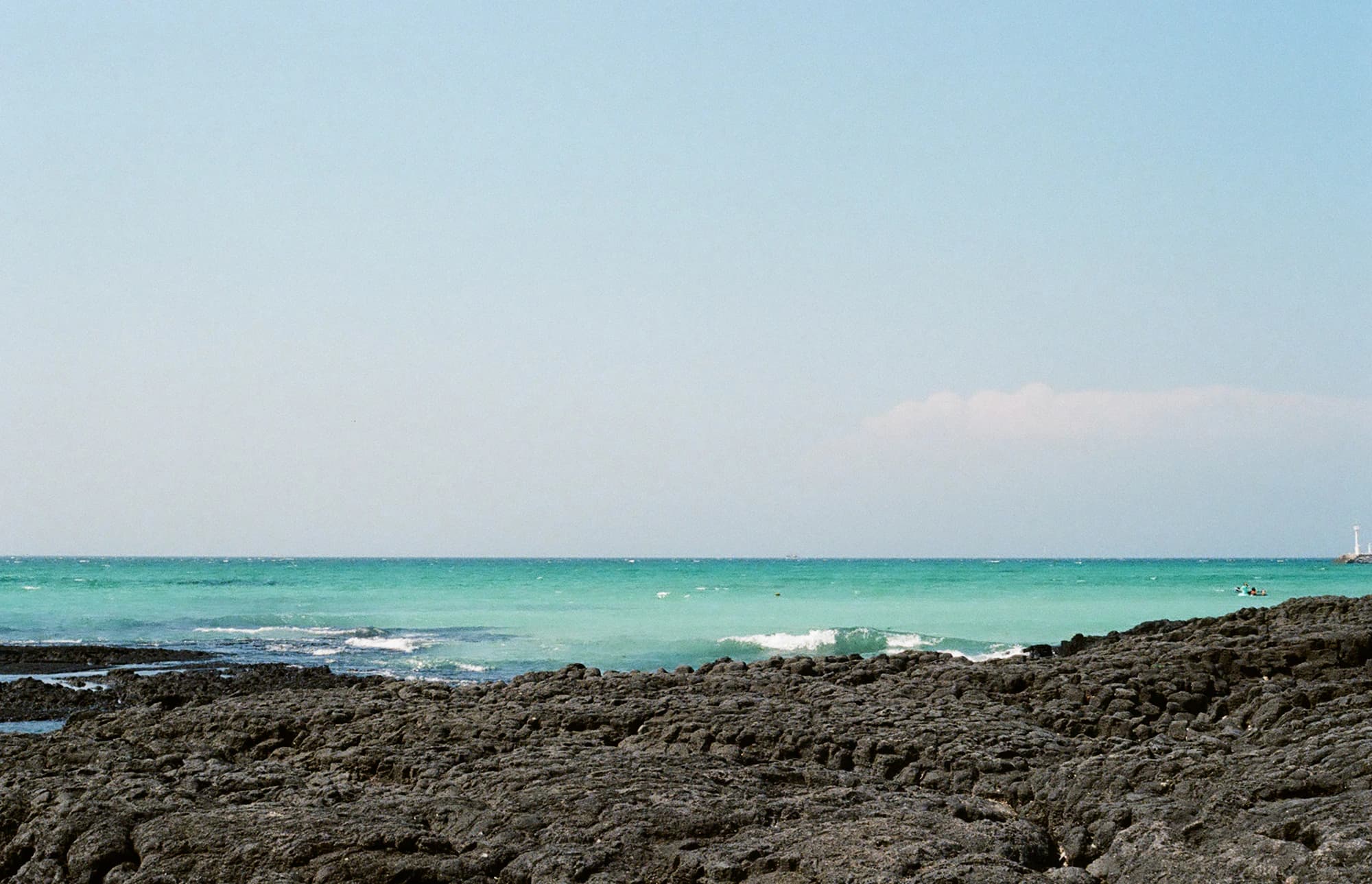 Emerald shallows and basalt coast in July
