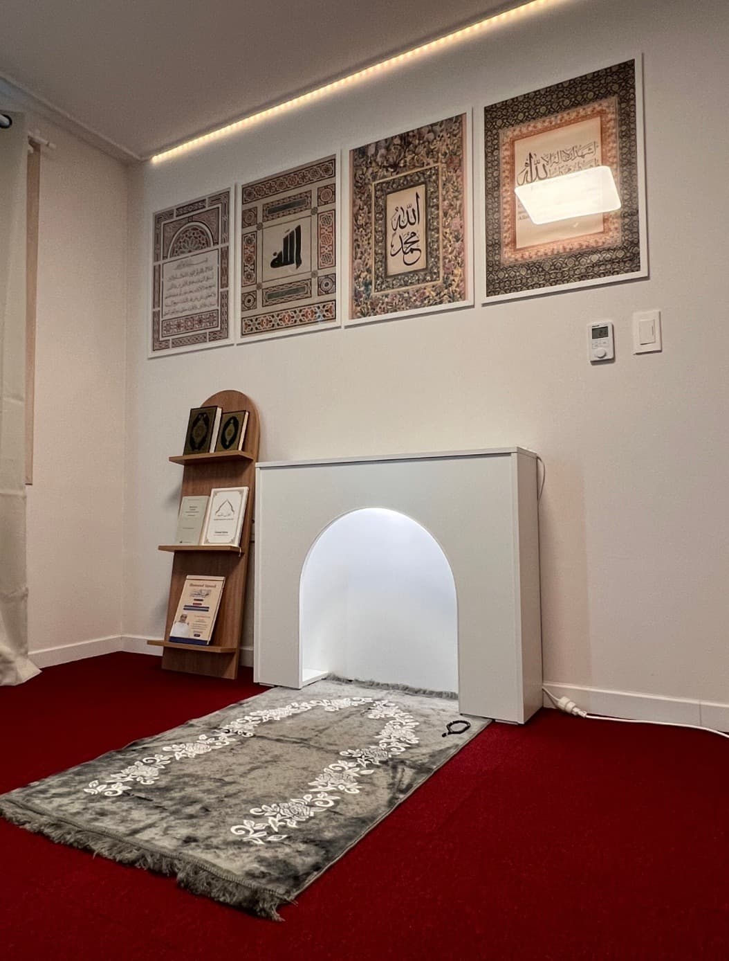 Dedicated prayer room with mihrab, prayer mats, and Islamic calligraphy