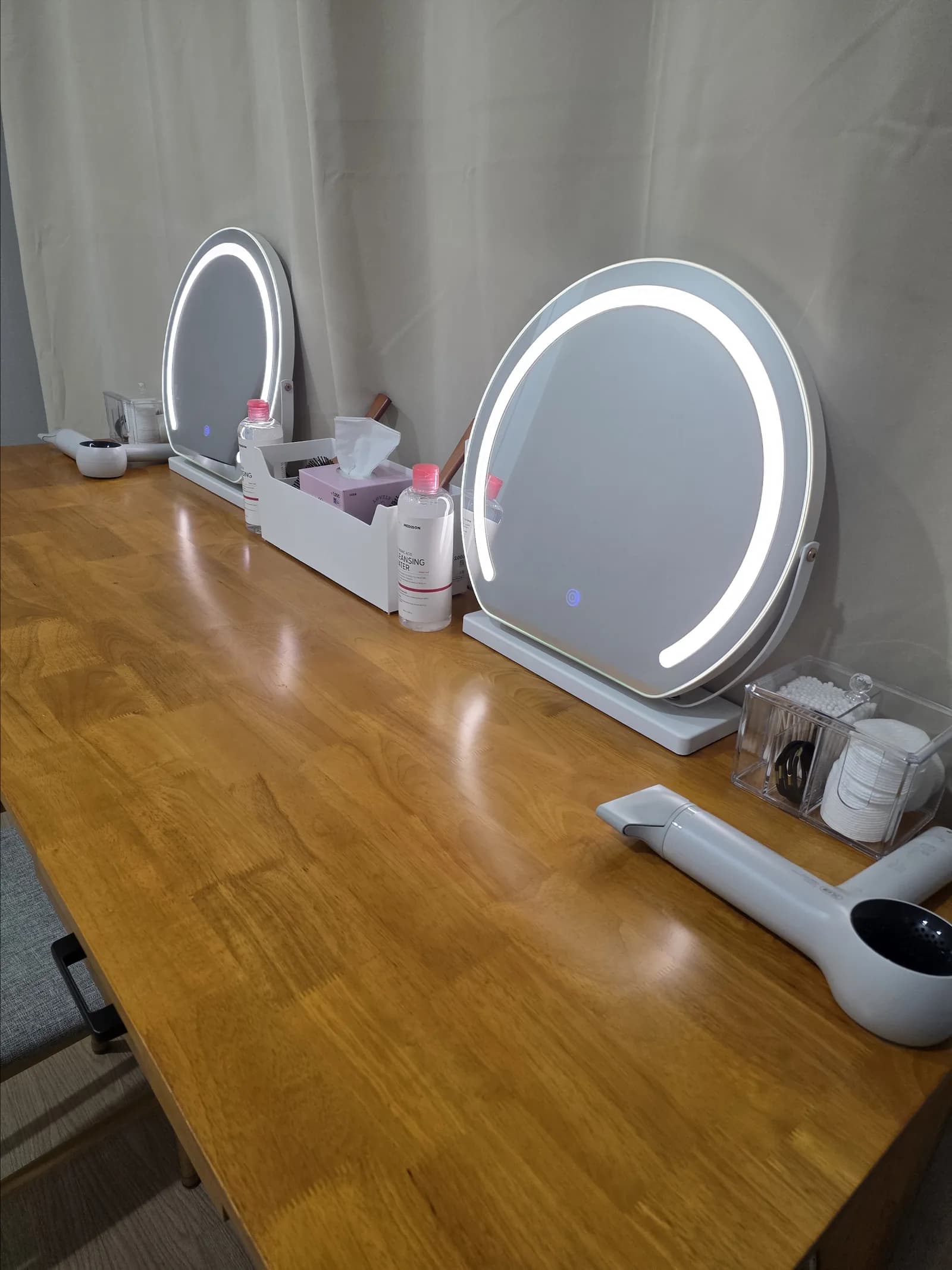 Vanity station with twin LED makeup mirrors, hair dryer and skincare amenities