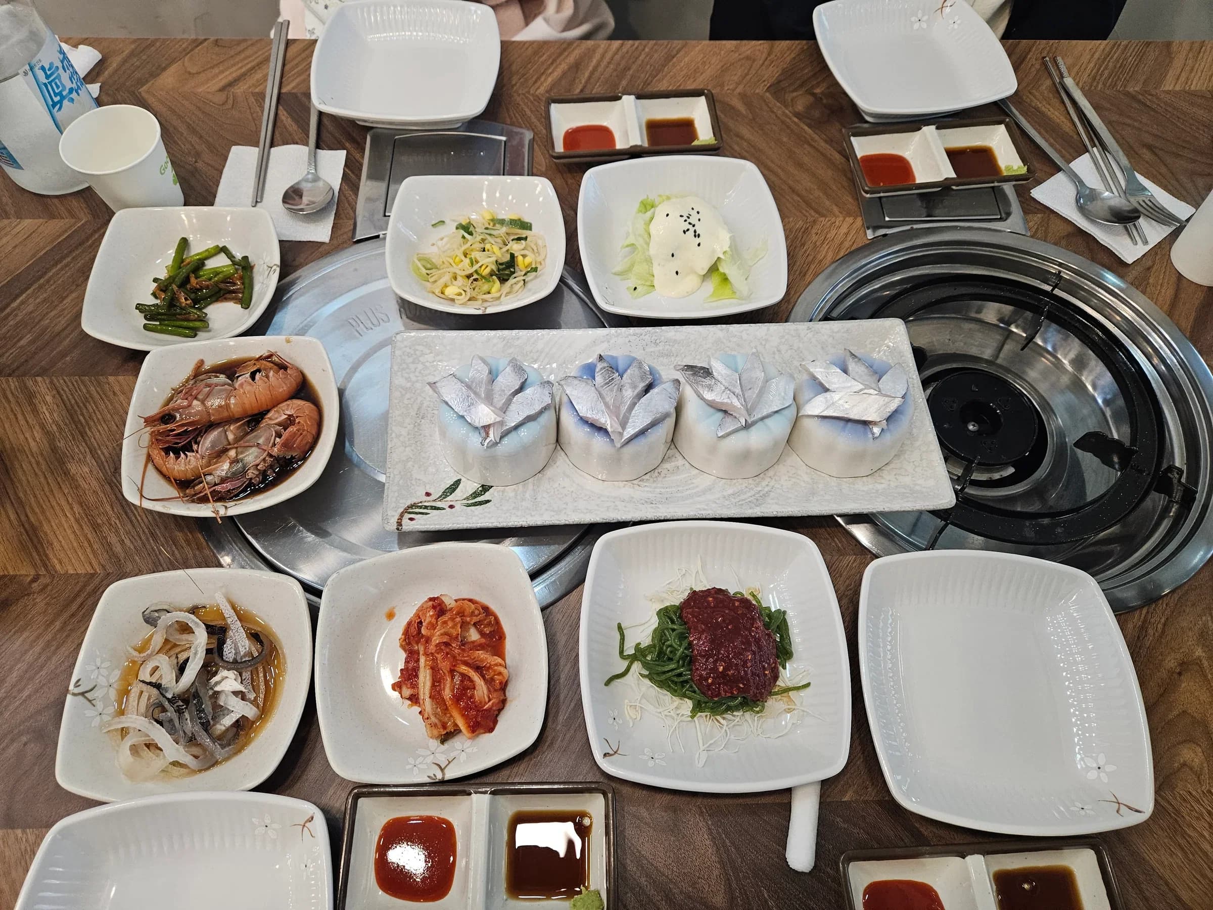 Korean seafood feast with grilled prawns and side dishes
