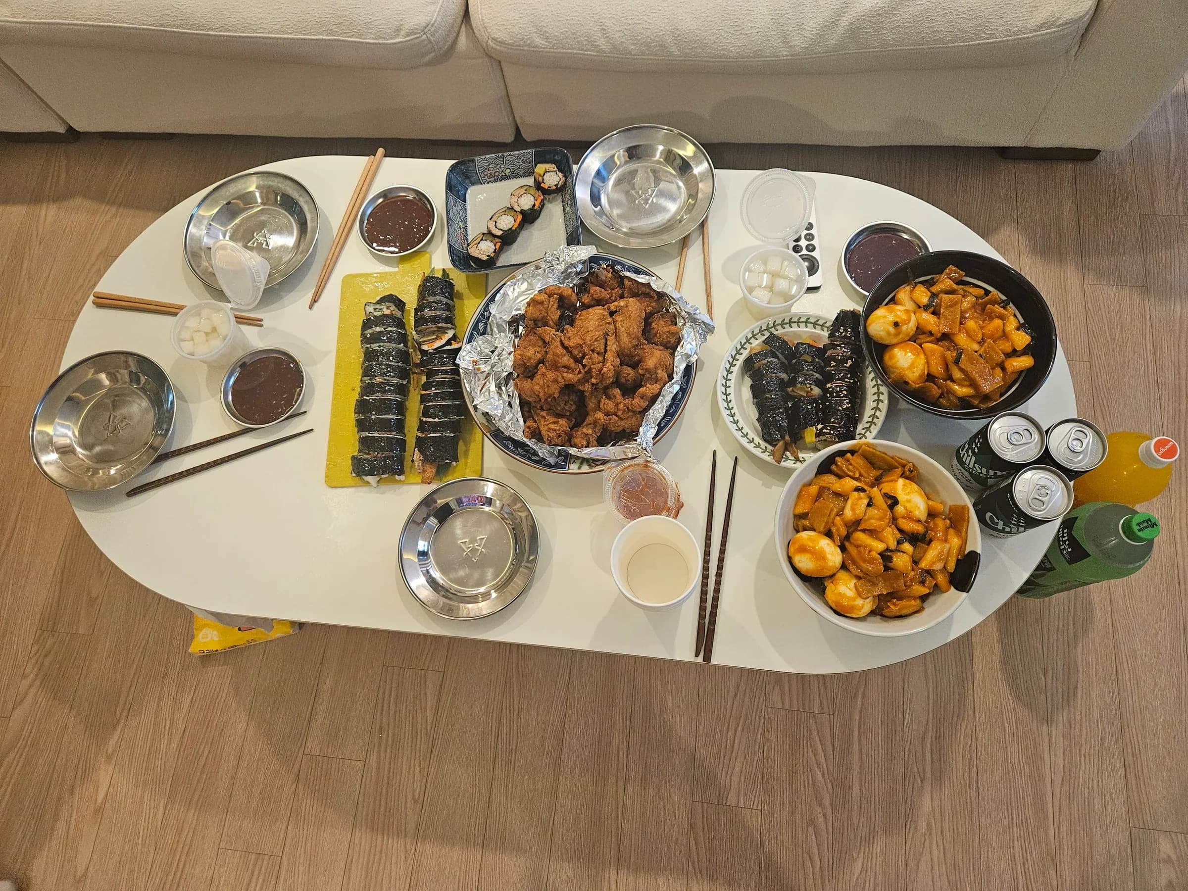 Group dinner spread at the villa — kimbap, fried chicken, side dishes