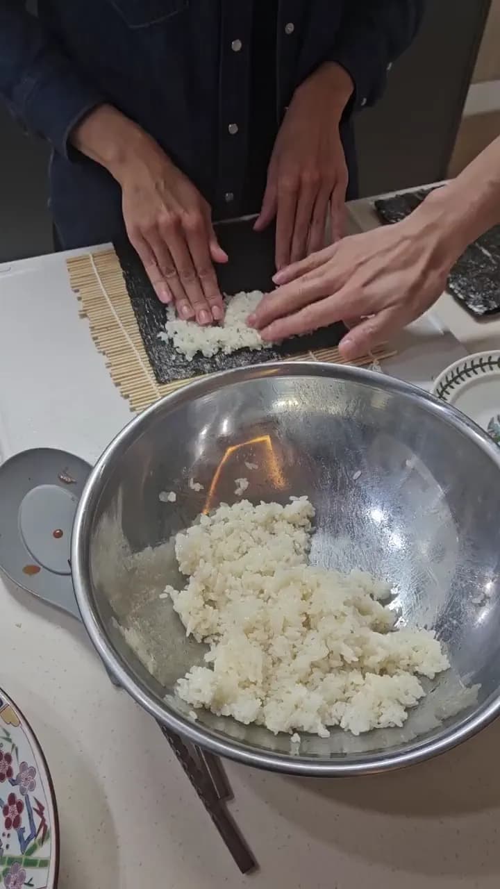 Pressing rice onto seaweed for kimbap