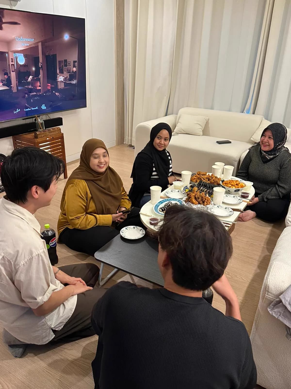 Group dinner at the villa — kimbap, fried chicken, and a movie on the TV
