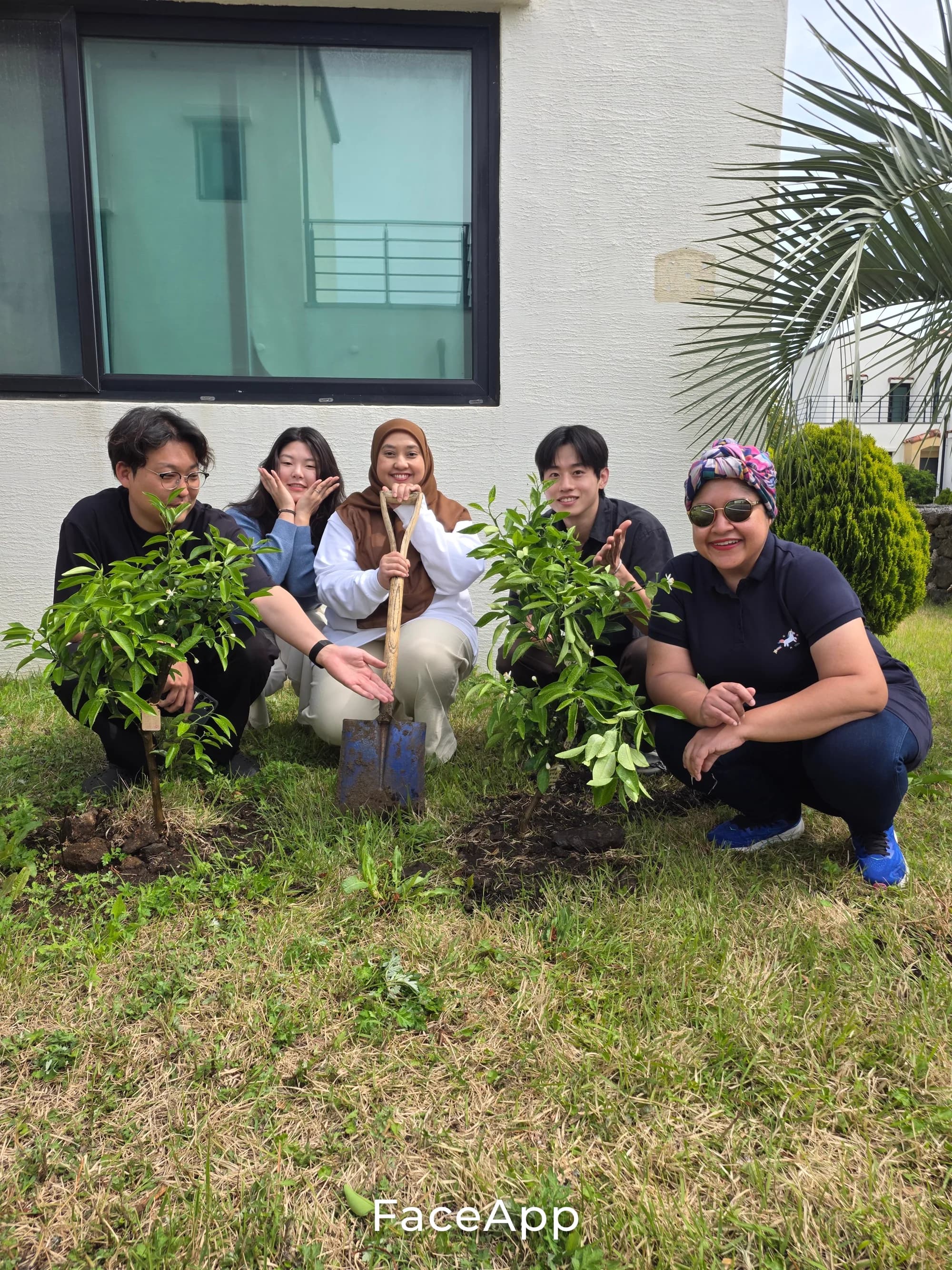 Sadaqah Jariyah — guests kneeling around a freshly planted tangerine tree at the villa