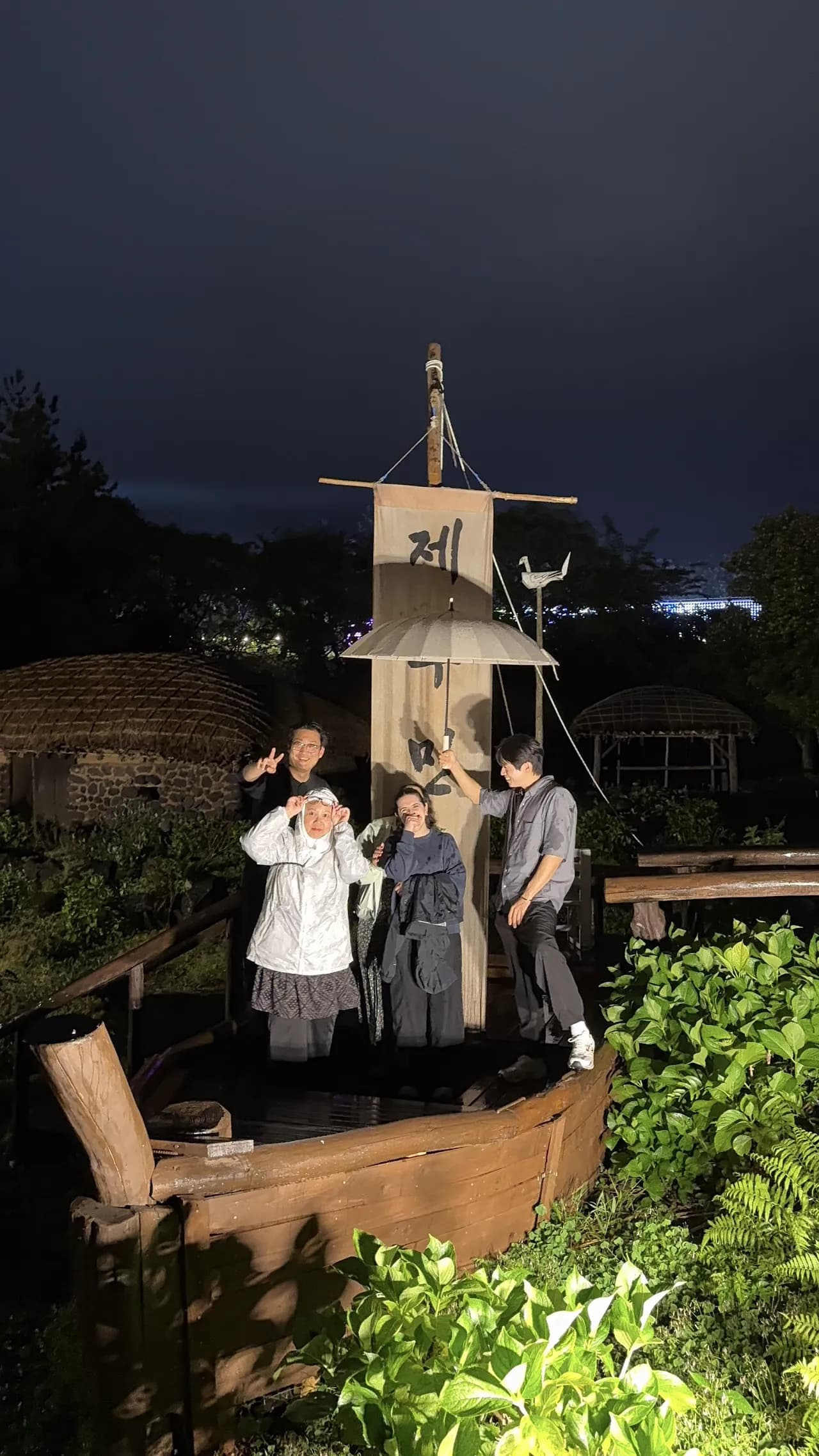 Posing by a lantern-lit traditional sailboat at night