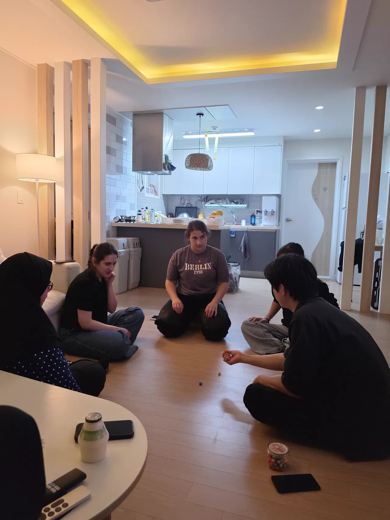 Game night on the villa floor — the whole cohort sitting in a circle